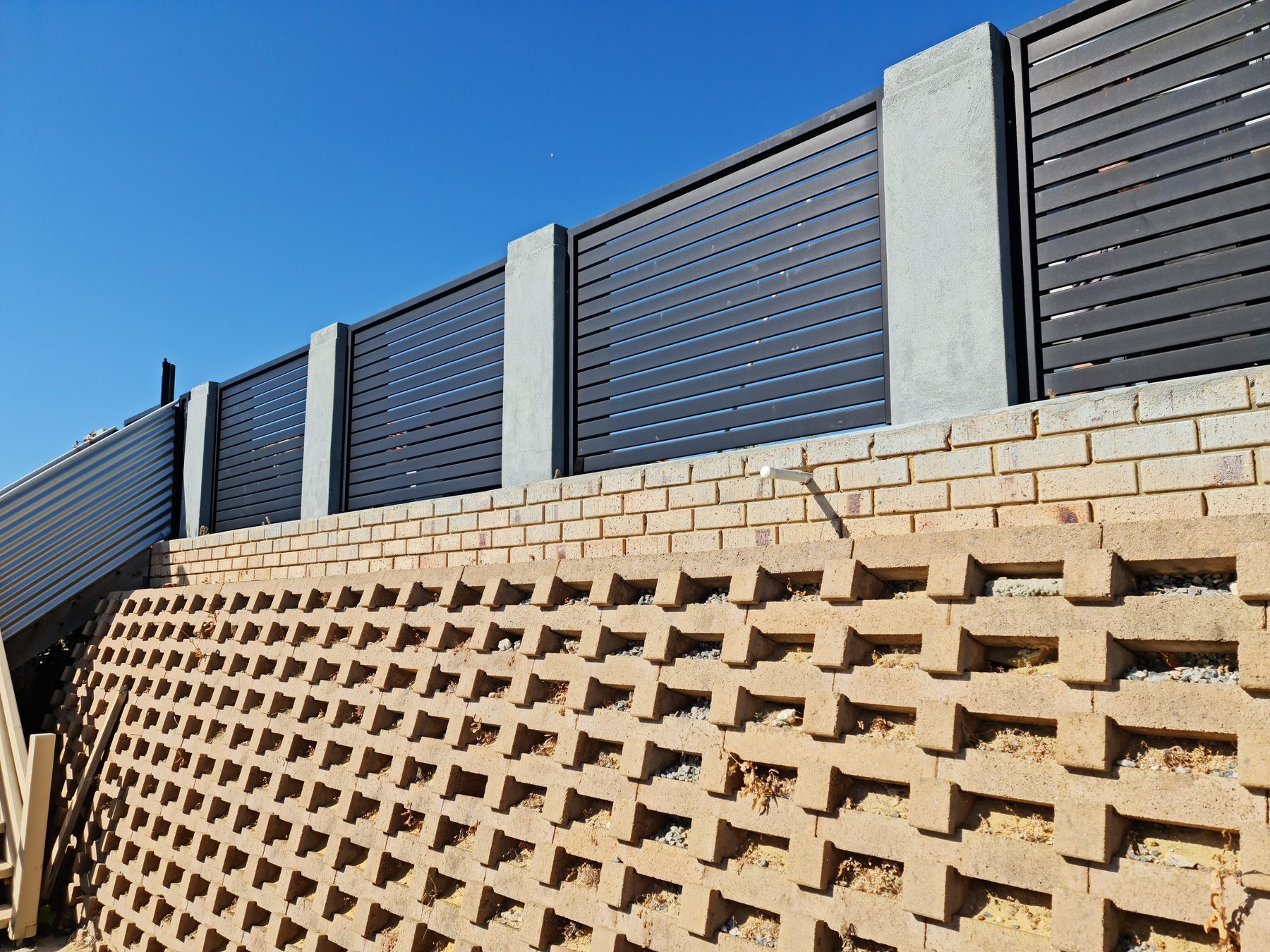 Charcoal slat fencing above brickwork in Perth
