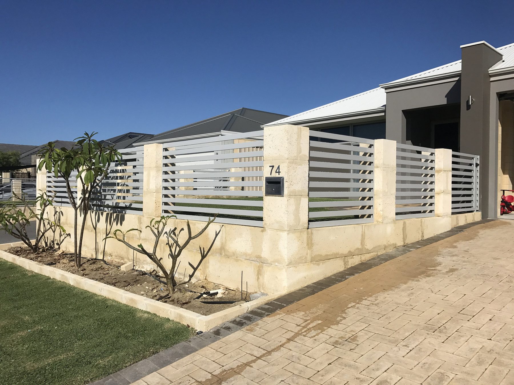White aluminium slat fencing with limestone piers, Perth streetfront
