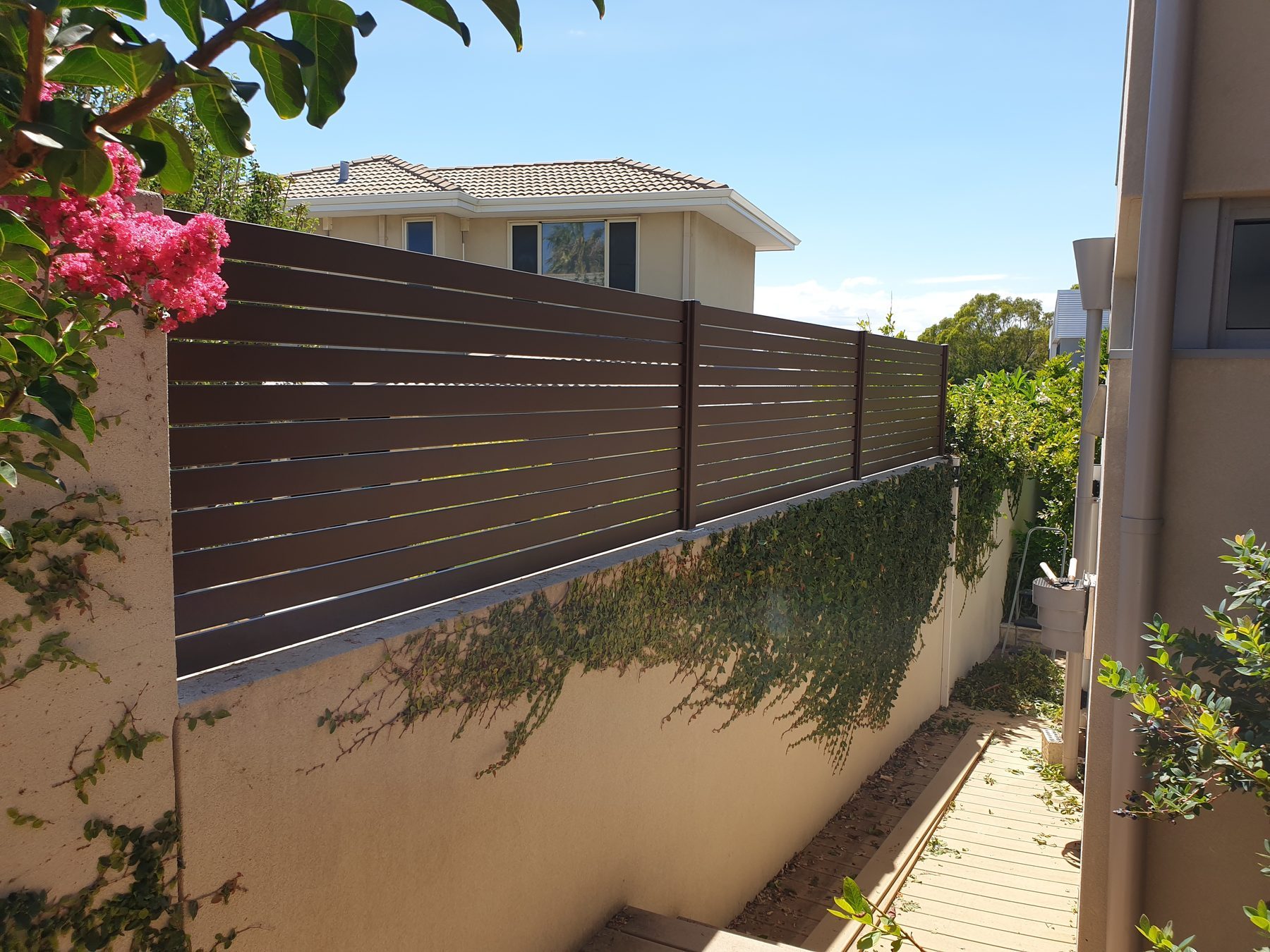Timber look slat fencing above a rendered wall in Perth