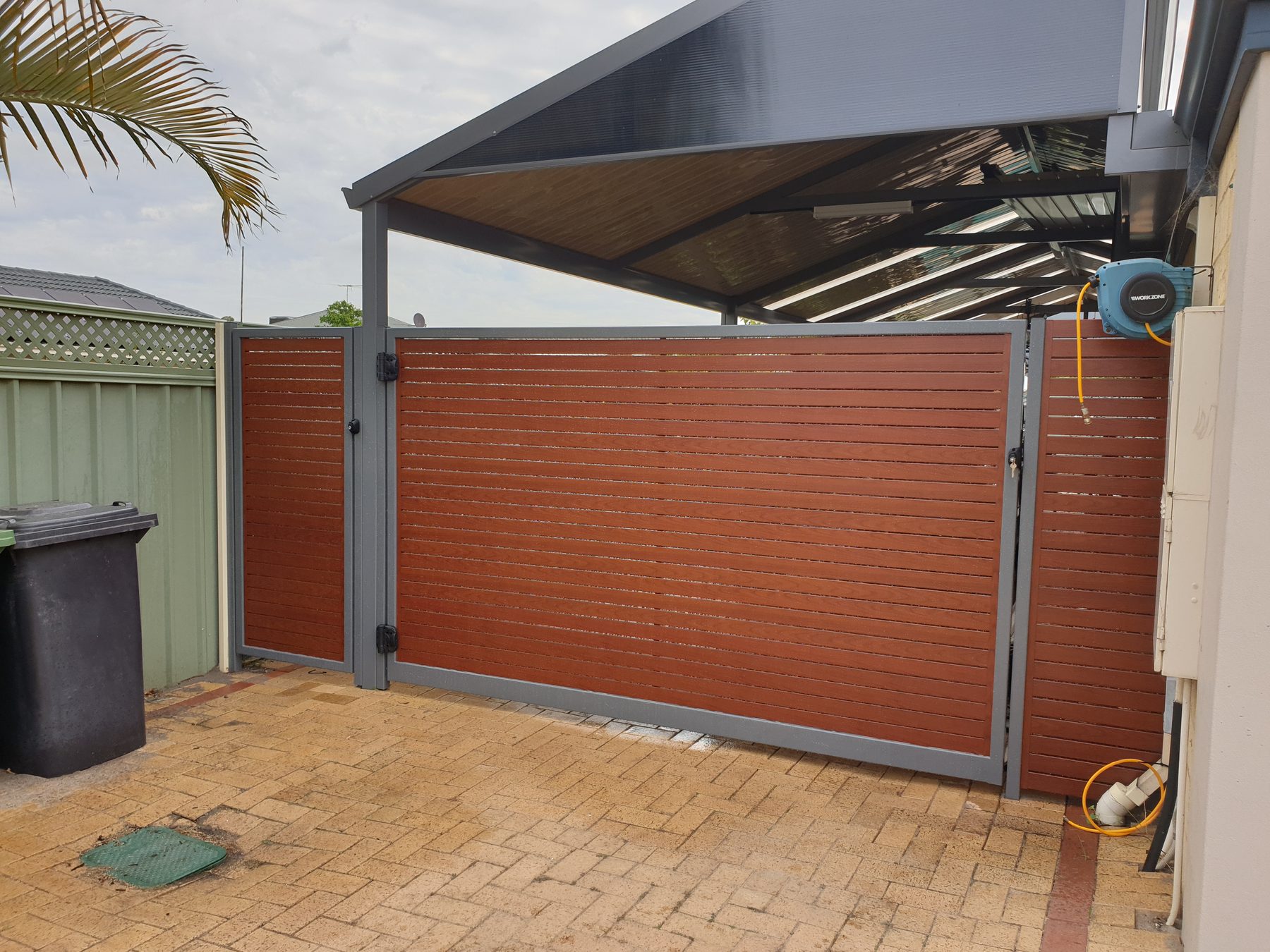 Timber look aluminium slatted gate beside a Perth patio