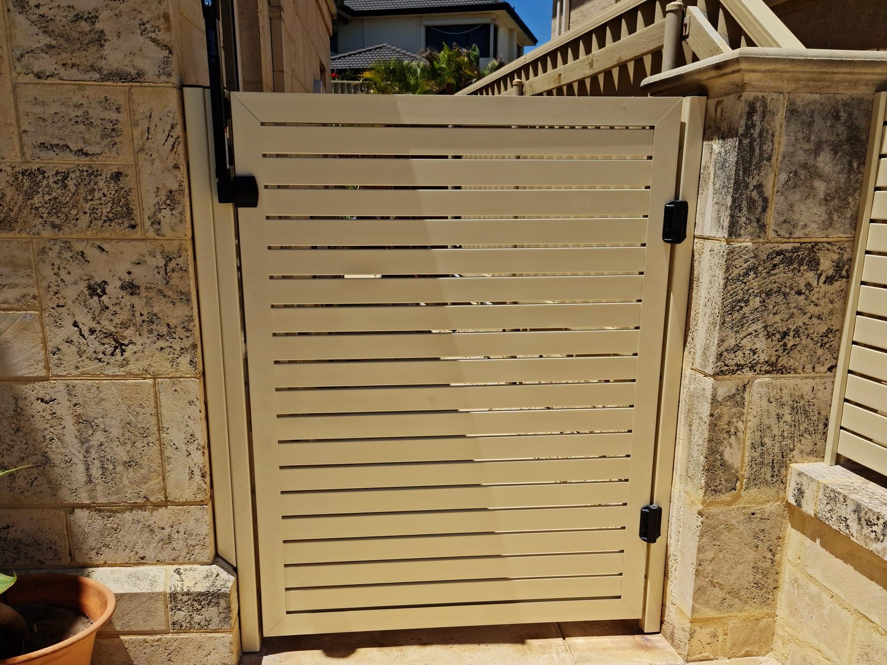 Cream gate between limestone piers in Perth