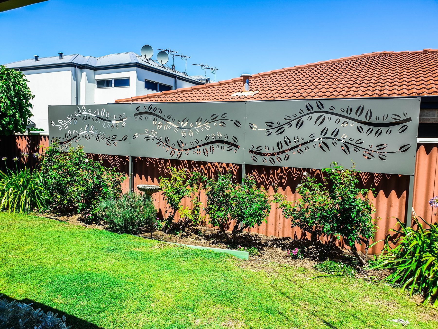 Leaf pattern laser cut screen above a fence in Perth